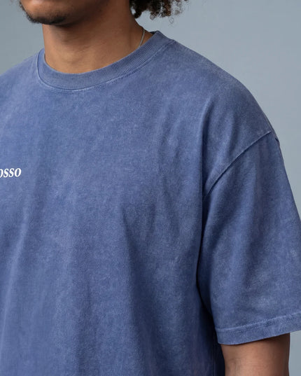 man wearing the MoGrosso blue Vintage Oversized T-shirt on a grey background with a clean outfit close-up