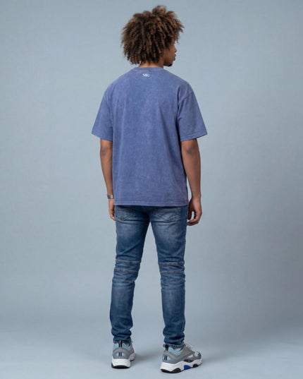 man wearing the MoGrosso blue Vintage Oversized T-shirt on a grey background with a clean outfit from the back
